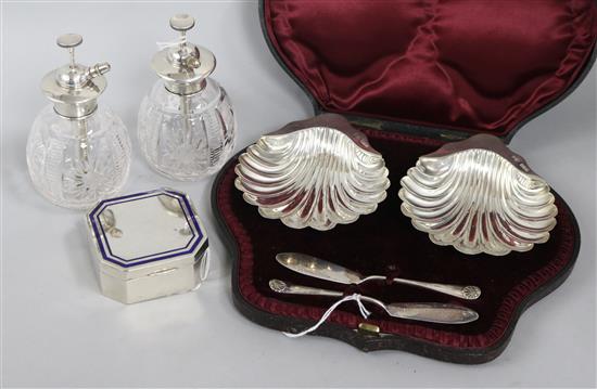 A pair of silver shell butter dishes and knives (cased), an enamel-banded silver box and a pair of silver-mounted glass atomisers